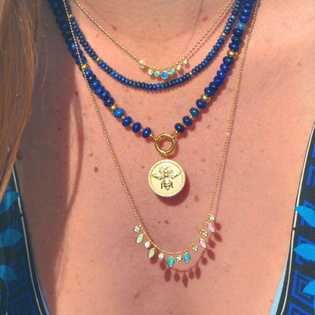 blue lapis raya charis layered necklaces with bee madallion and aurora lights opal layering