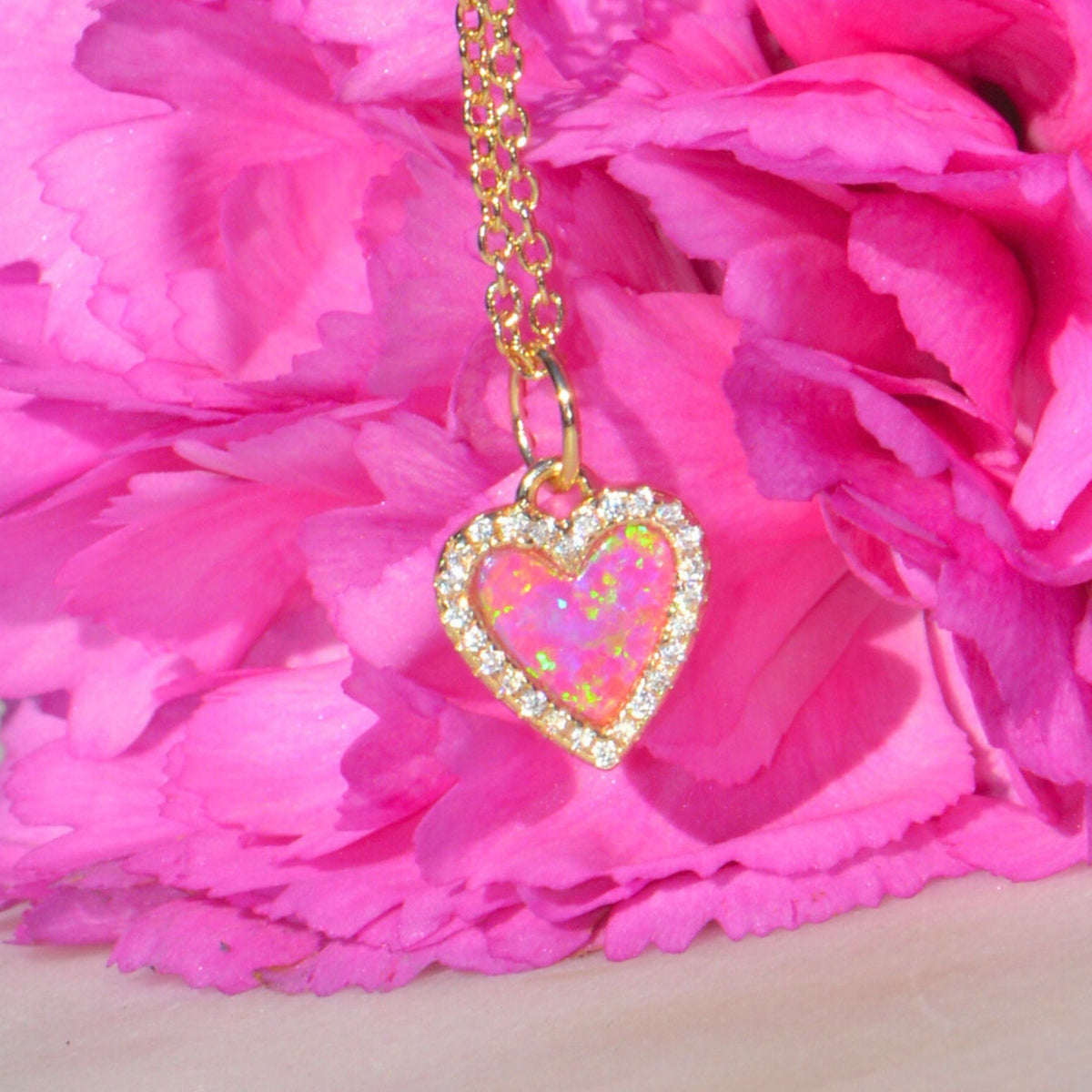 Necklace with a heart pendant on pink flowers