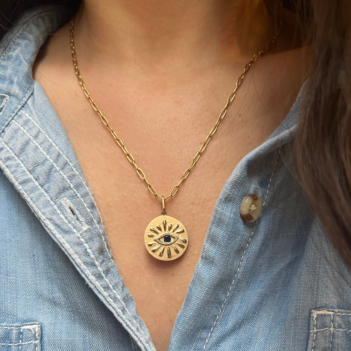 large evil eye disk necklace with blue sapphire and rays paperclip chain lifestyle