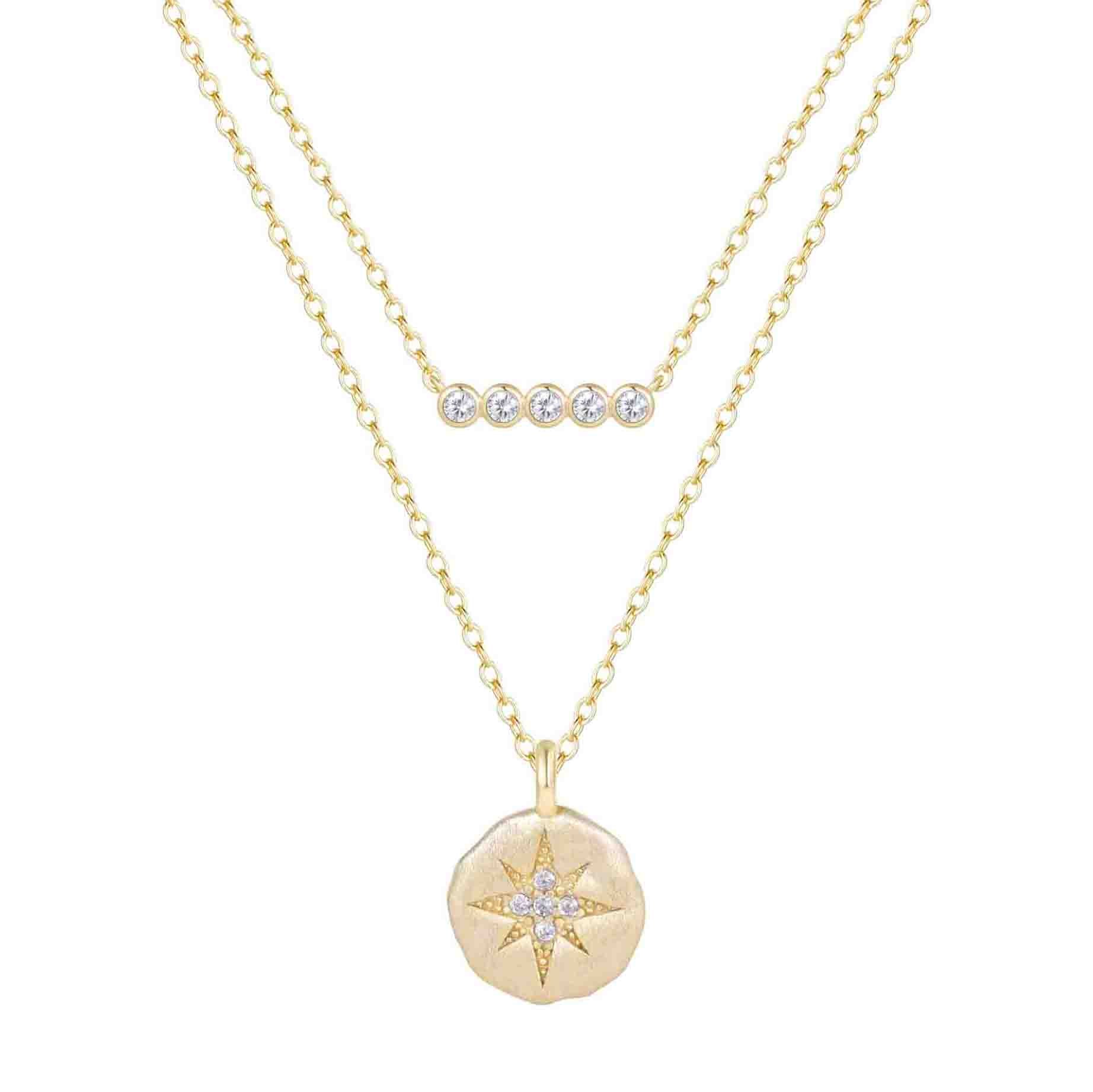 Gold necklace with star pendant and small round pendant on a white background