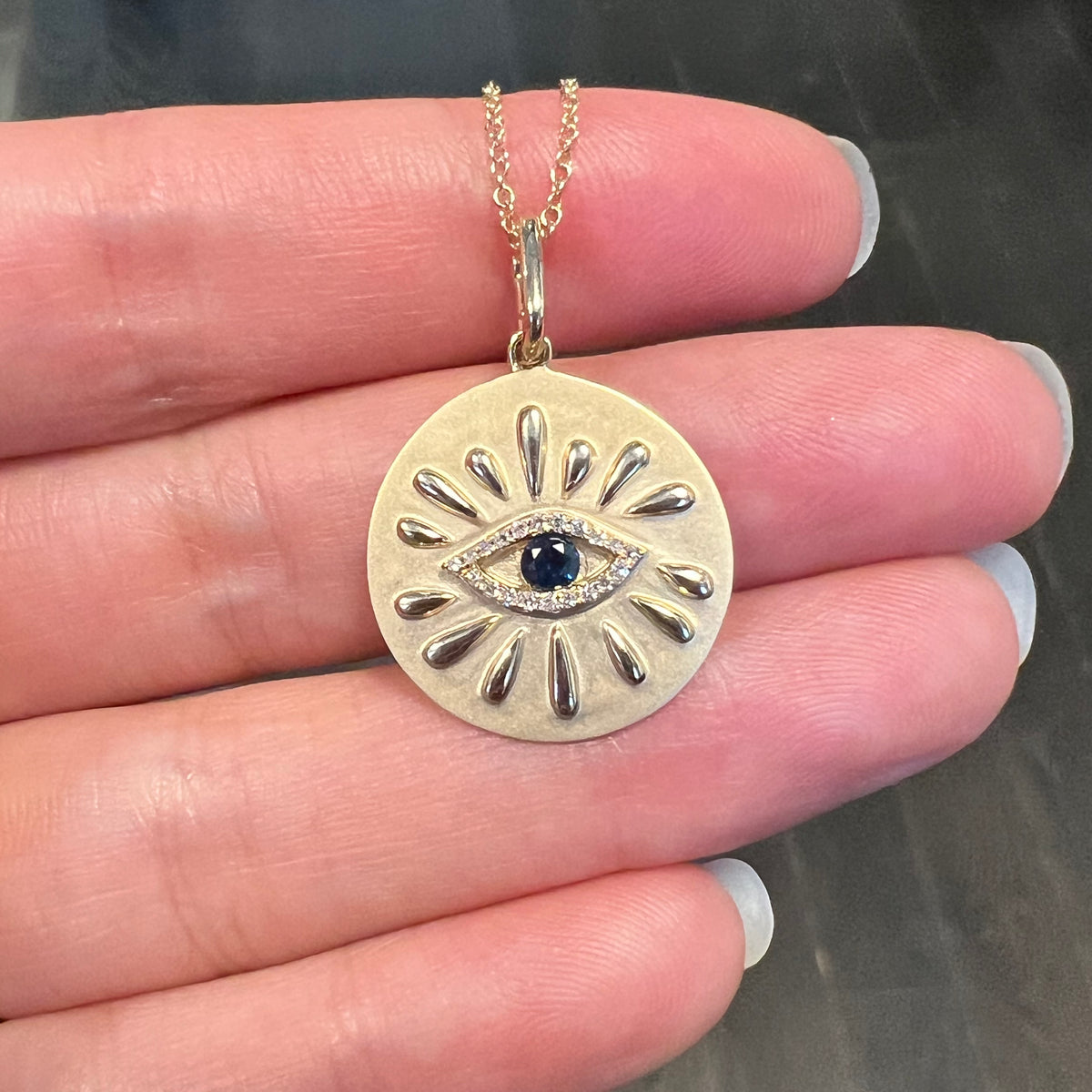 large evil eye disk necklace with blue sapphire and rays