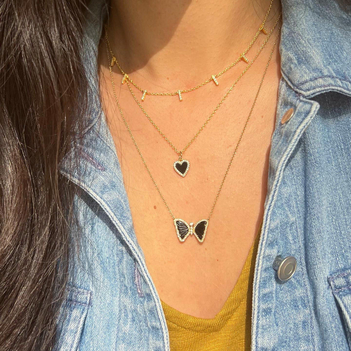 black onyx mini heart necklace layered with bar choker and back butterfly
