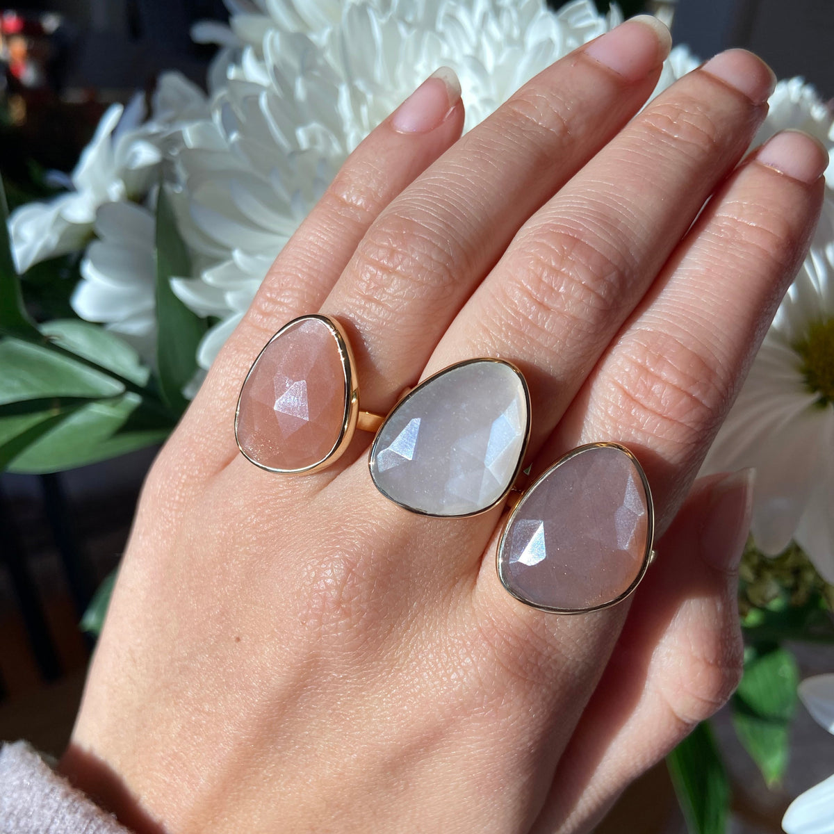three moonstone rings in peach, white and mauve moonstone